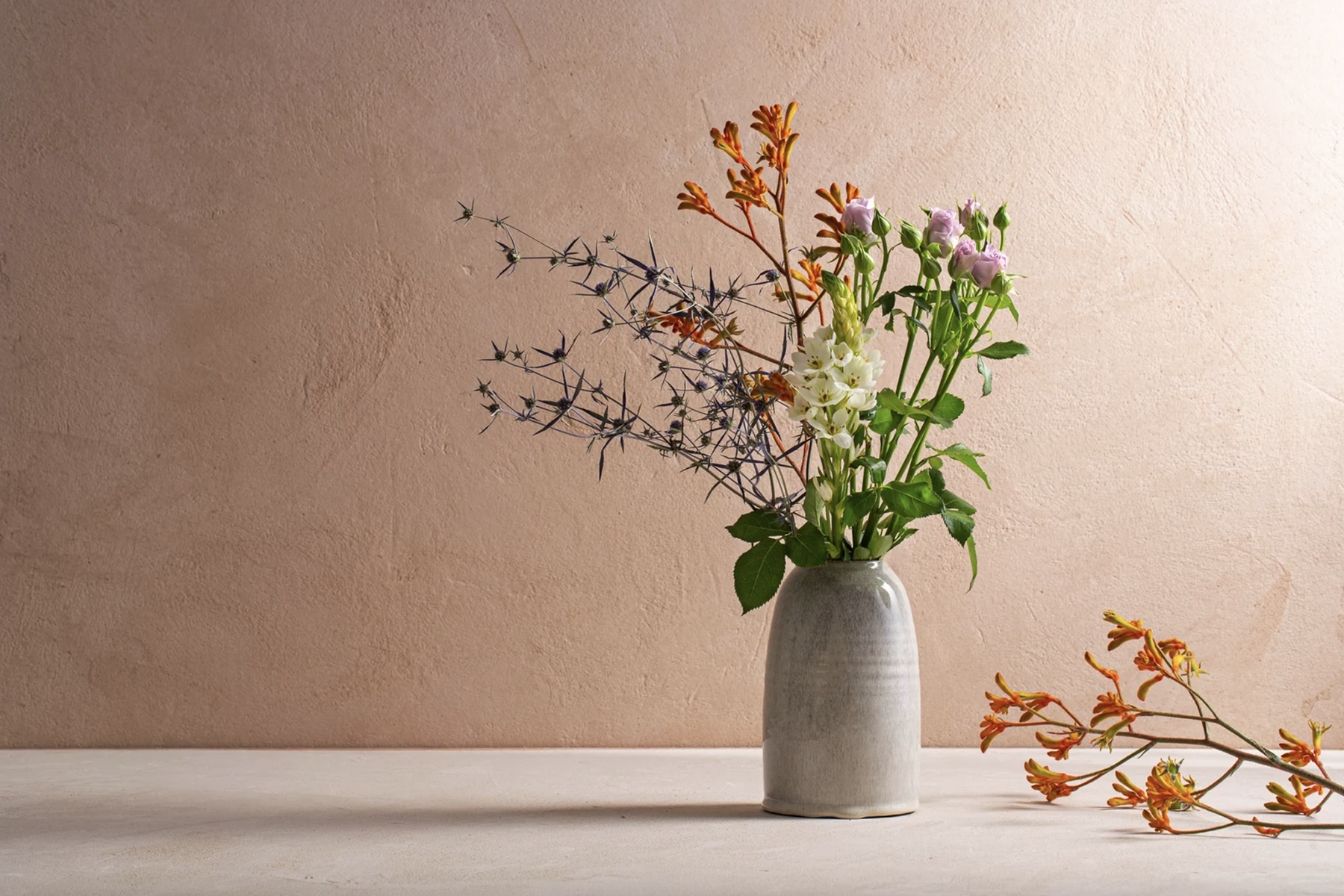Ceramic vase holding a variety of flowers.