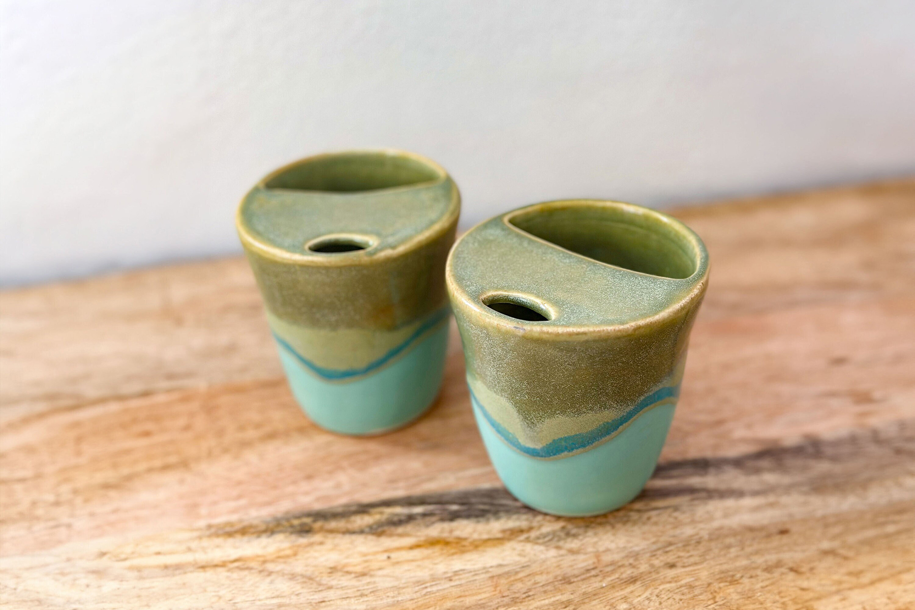 Two handmade ceramic sippy mug cups.