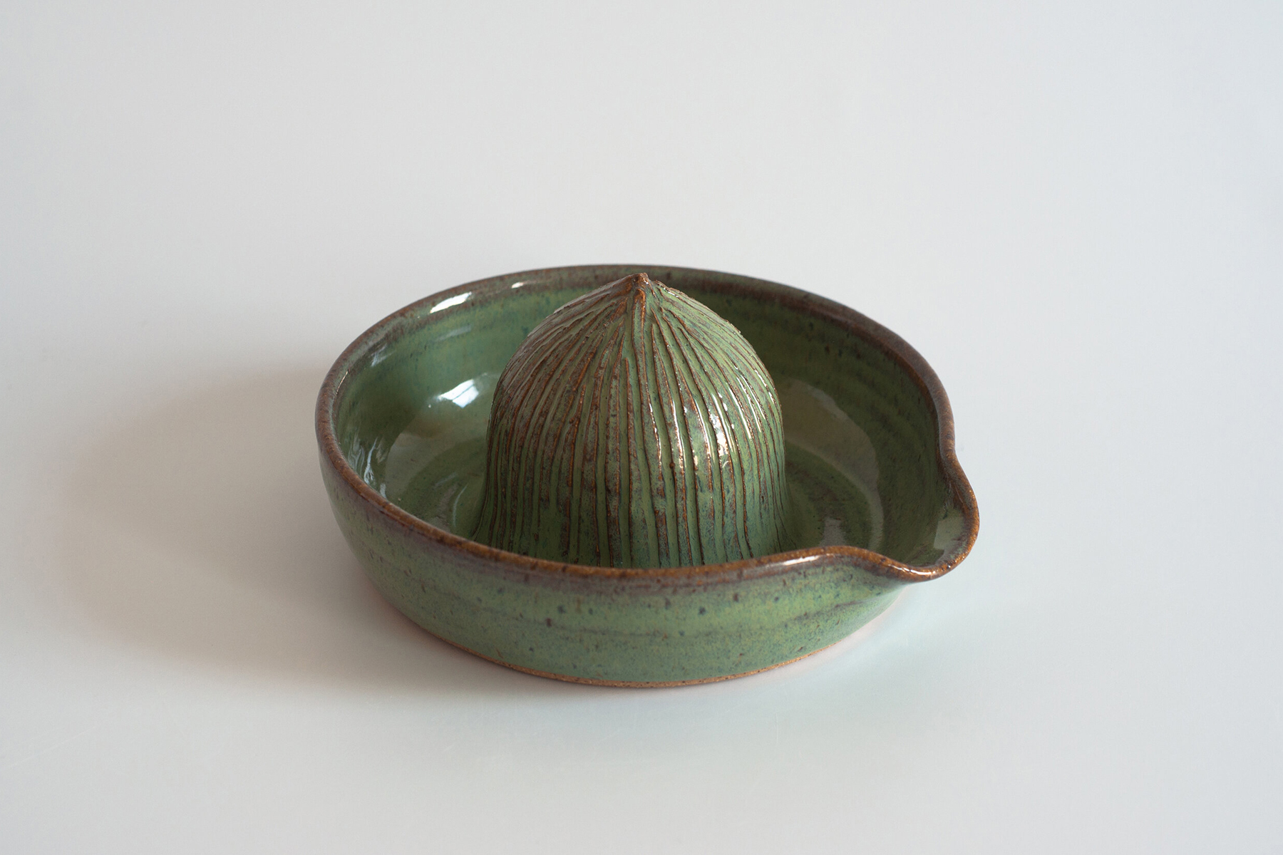 Green glazed wheel-thrown citrus reamer.